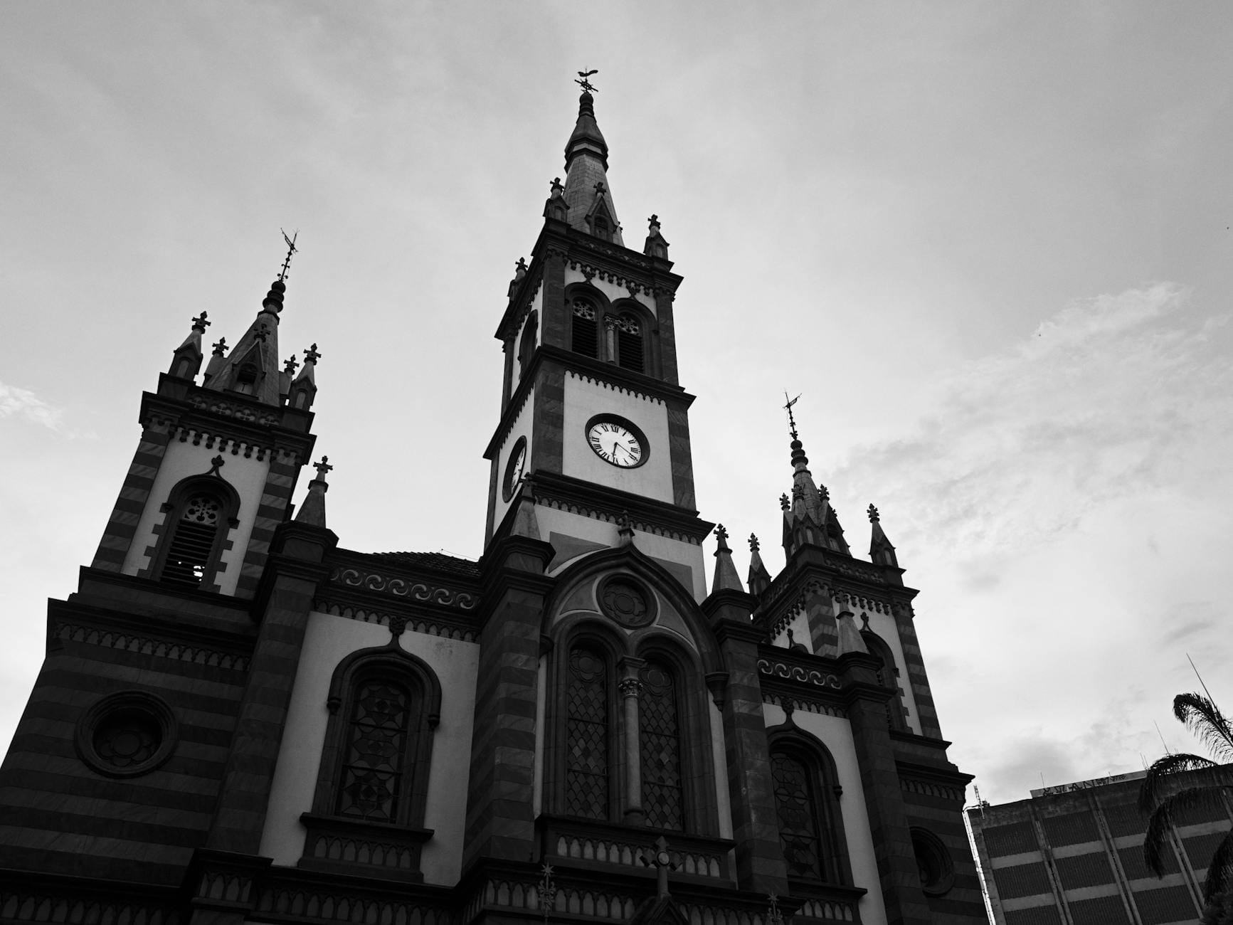 Czarno-białe ujęcie neogotyckiego kościoła z wieżą zegarową