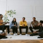 Grupa znajomych różnego pochodzenia modli się i śpiewa w salonie