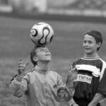 Nastolatki grające w piłkę i żonglujące głową na boisku