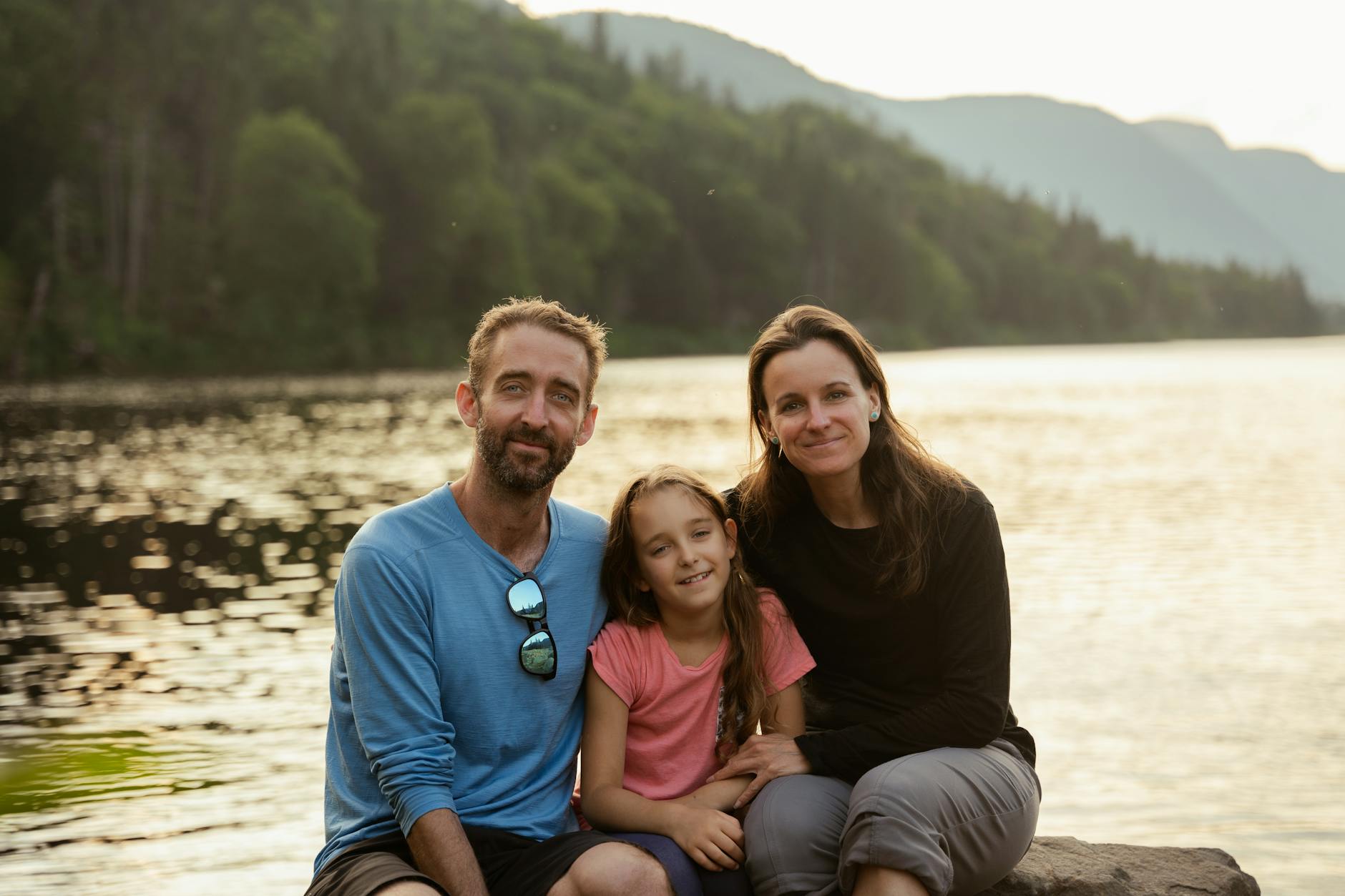 Rodzina z dzieckiem odpoczywa nad jeziorem w otoczeniu gór
