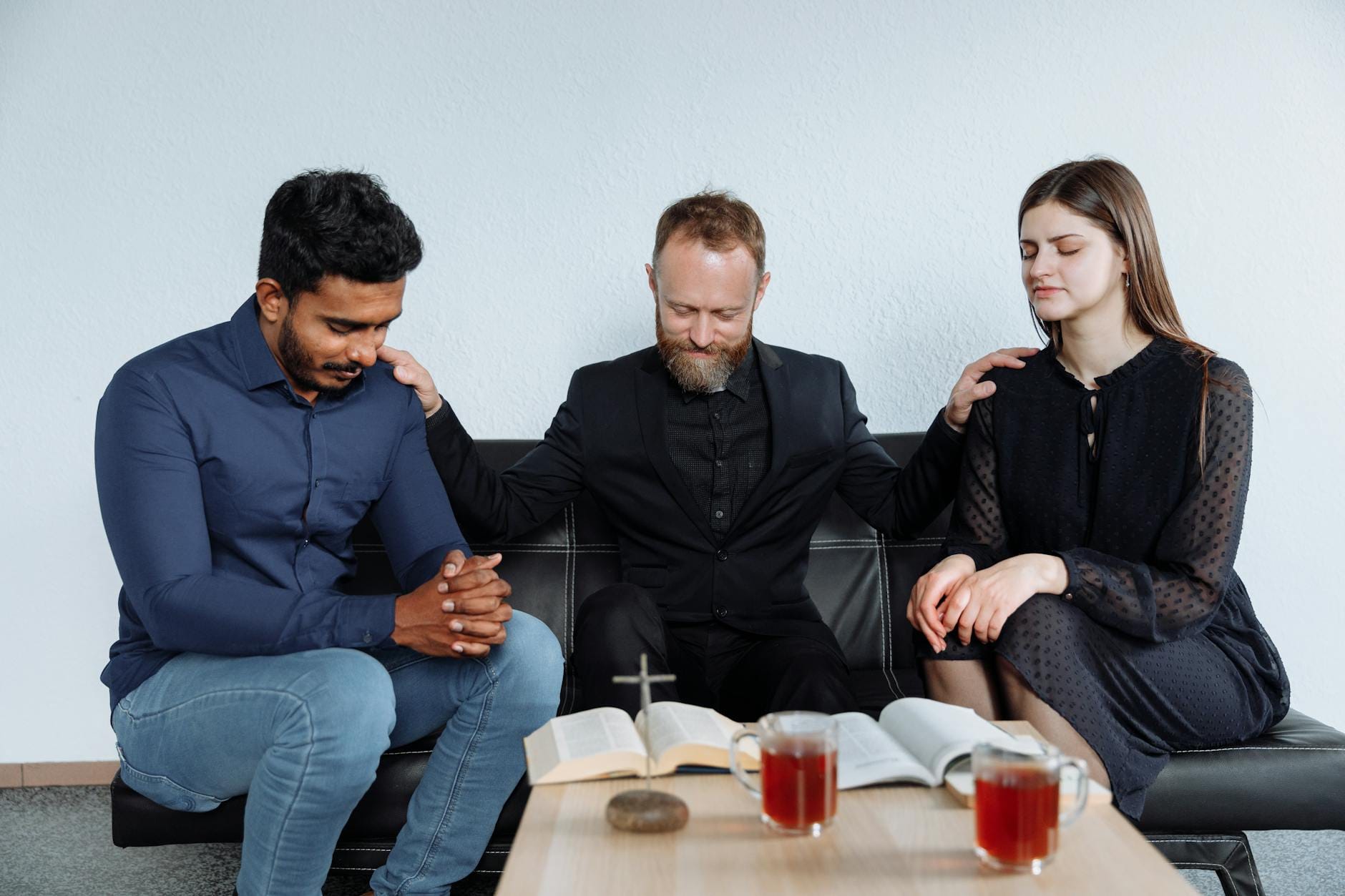 Dorośli różnych wyznań modlą się razem i czytają Biblię w sali