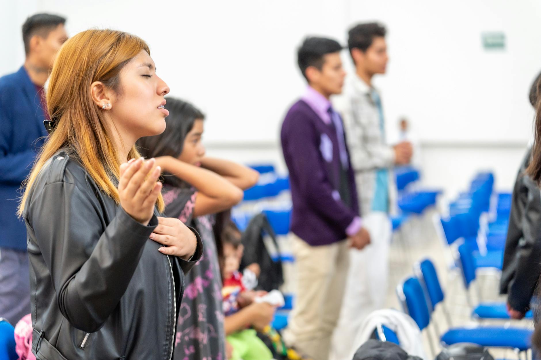 Wierni różnych narodowości modlą się wspólnie w sali w Ciudad de México