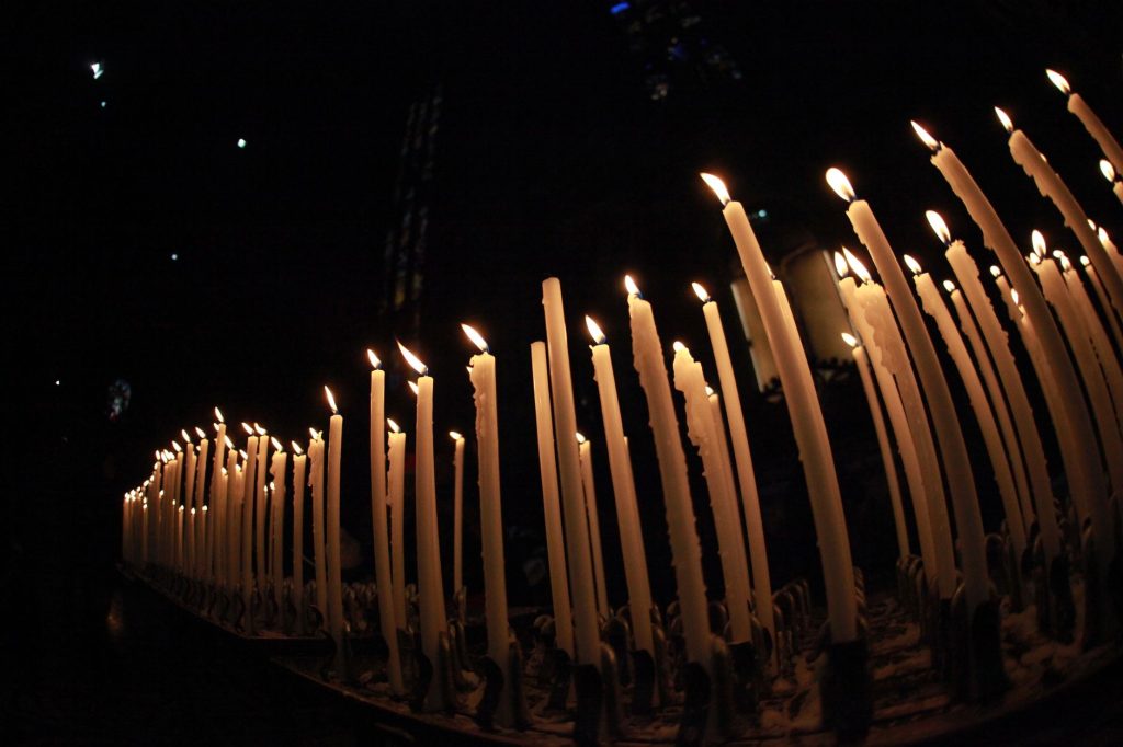 Rząd zapalonych świec w ciemności tworzących spokojny nastrój